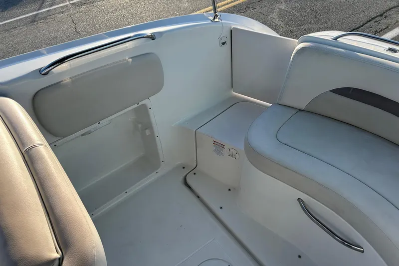 Slide: The Image of 2005 Chaparral Sunesta 252 boat interior with white seating and storage compartments. - 18