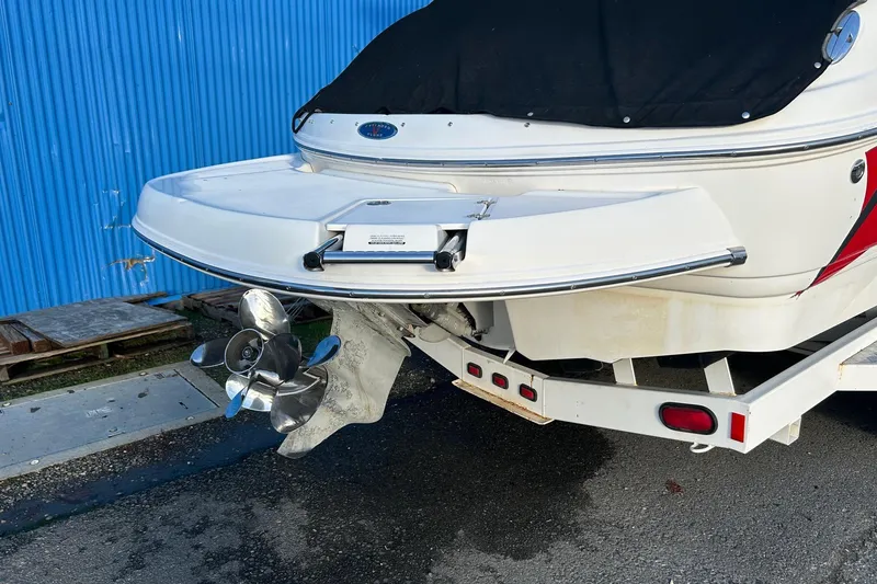 Slide: The Image of 2005 Chaparral Sunesta 252 boat stern with propeller, on trailer, near blue wall. - 2