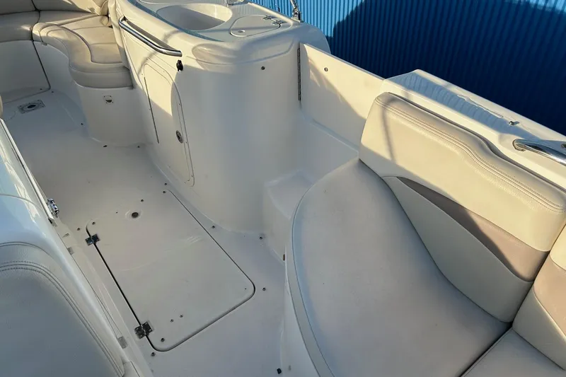 Slide: The Image of 2005 Chaparral Sunesta 252 boat interior with white seating and storage compartments. - 22