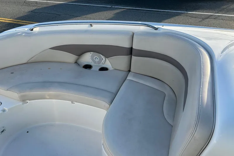 Slide: The Image of 2005 Chaparral Sunesta 252 boat interior with white cushioned seating and cup holders. - 23