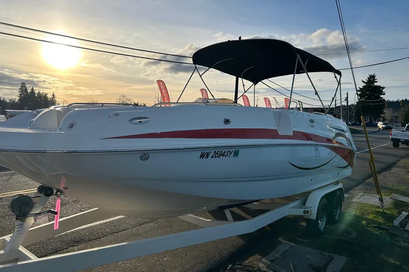 Slide: The Image of 2005 Chaparral Sunesta 252 boat on trailer at sunset, with canopy and red accents. - 4