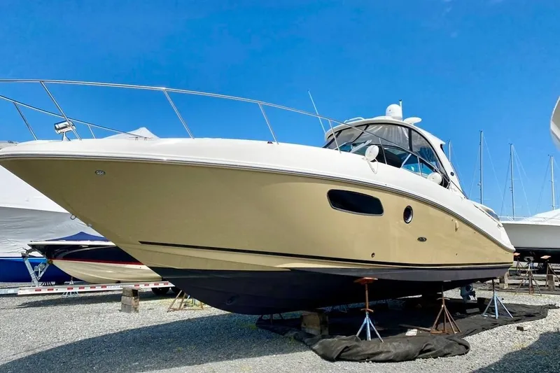 The Image of 2012 Sea Ray 370 Sundancer yacht on dry dock under clear blue sky. - 0