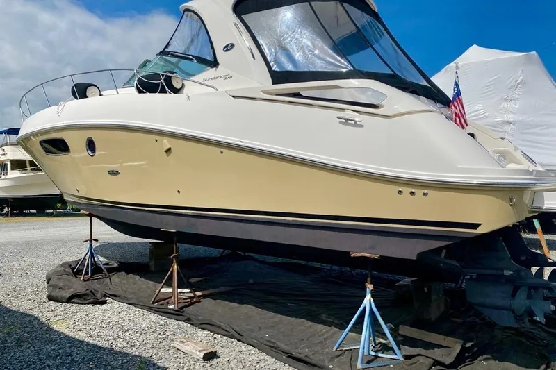 Slide: The Image of 2012 Sea Ray 370 Sundancer yacht on stands, displayed outdoors under a blue sky. - 1