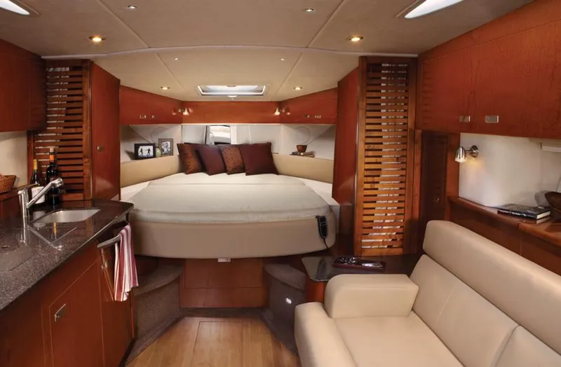 Slide: The Image of Manufacturer Provided Image: Luxurious interior of 2012 Sea Ray 370 Sundancer yacht with bed, sofa, and kitchenette. - 25