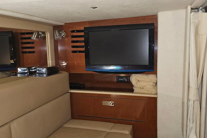 Slide: The Image of Interior of 2012 Sea Ray 370 Sundancer with TV and wooden cabinetry. - 28