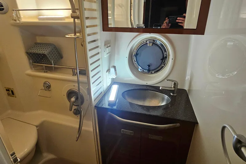 Slide: The Image of Luxurious bathroom in 2012 Sea Ray 370 Sundancer yacht with modern fixtures and porthole window. - 31