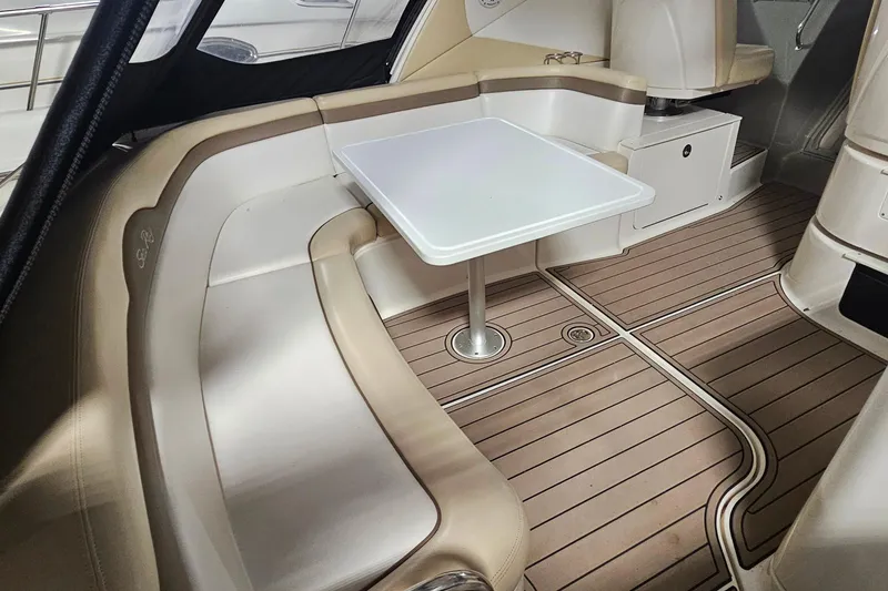 Slide: The Image of 2012 Sea Ray 370 Sundancer interior with beige seating and a white table. - 5