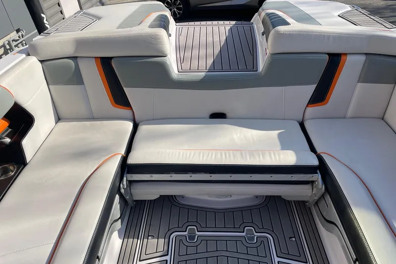 Slide: The Image of 2015 Nautique Super Air Nautique G23 interior with white and gray seating, orange accents. - 8