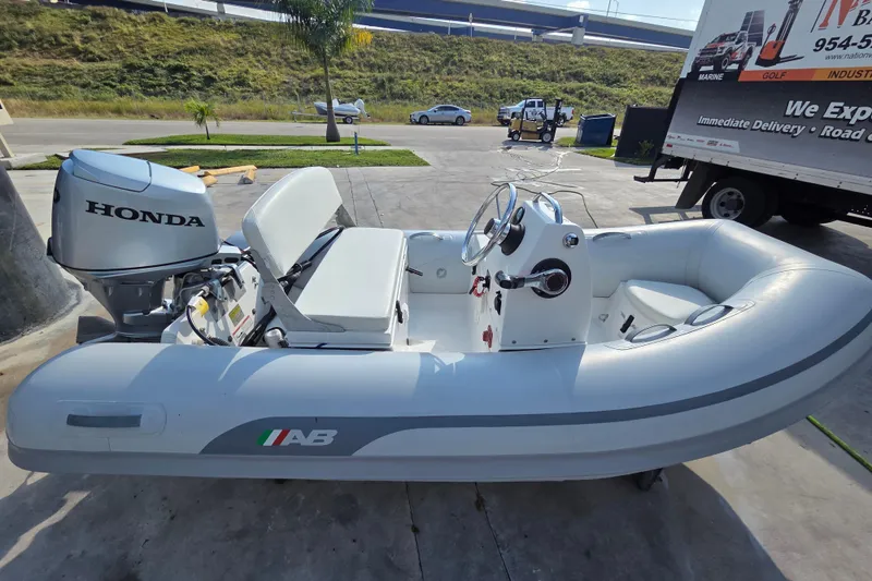 The Image of 2014 AB Inflatables 10 VSX boat with Honda outboard motor, parked outdoors. - 0