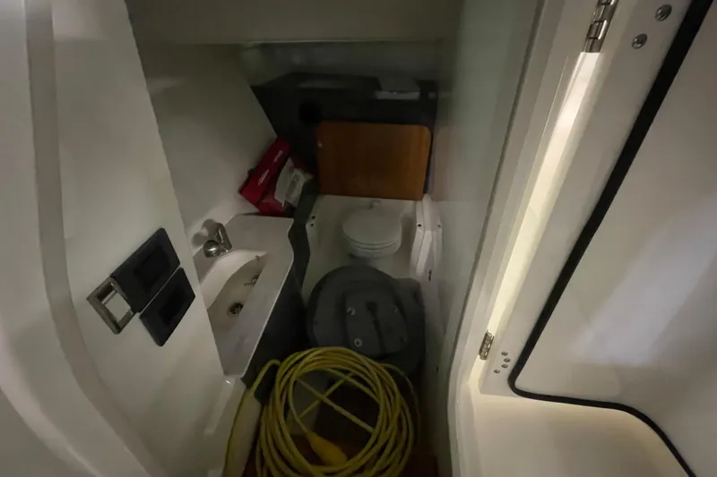 Slide: The Image of Interior of 2025 Boston Whaler 330 Vantage boat, featuring compact bathroom amenities. - 11