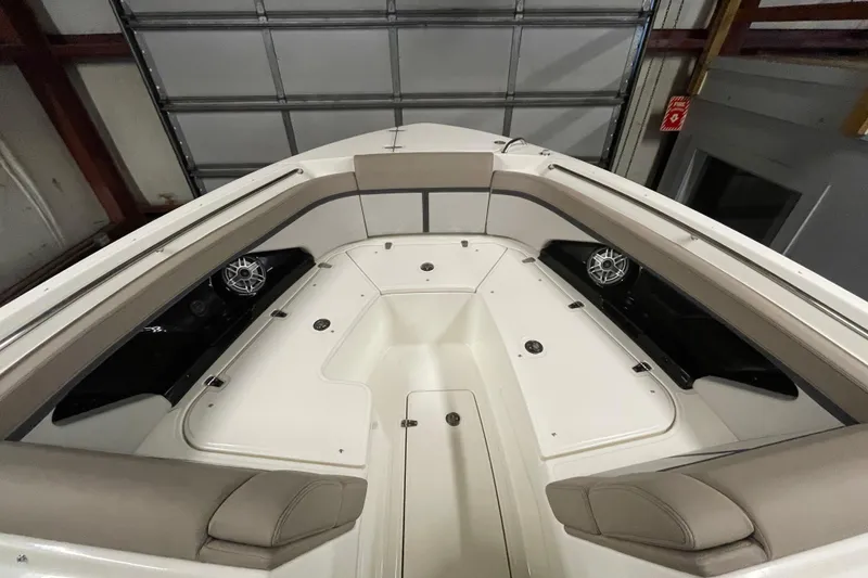 Slide: The Image of 2025 Boston Whaler 330 Vantage boat interior with cushioned seating and speakers. - 14
