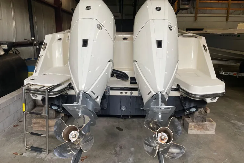 Slide: The Image of 2025 Boston Whaler 330 Vantage with dual outboard engines in a storage facility. - 16