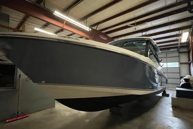 Slide: The Image of 2025 Boston Whaler 330 Vantage boat in a warehouse setting. - 2