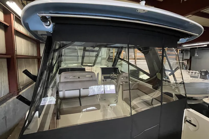 Slide: The Image of 2025 Boston Whaler 330 Vantage boat interior with seating and dashboard in a storage facility. - 4