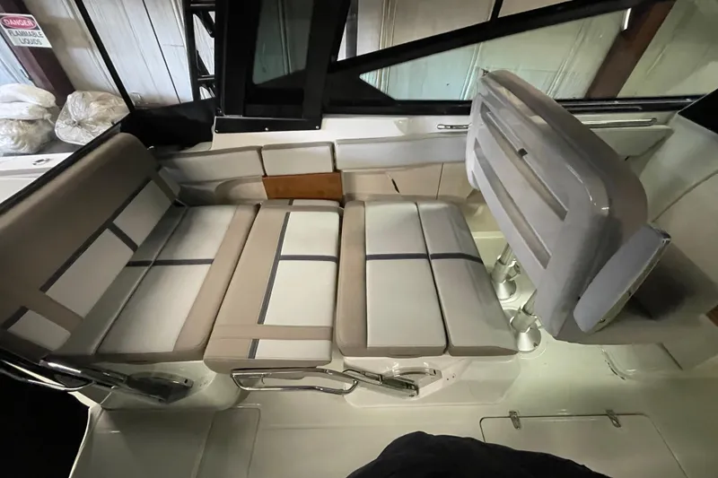 Slide: The Image of 2025 Boston Whaler 330 Vantage interior seating with beige cushions and sleek design. - 7
