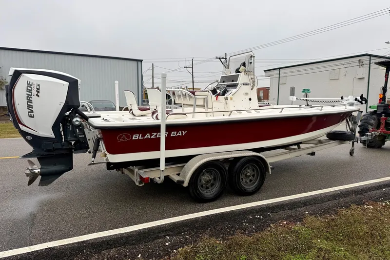 Slide: The Image of 2003 Blazer 2220 Bay boat on trailer with Evinrude engine, parked on street. - 4