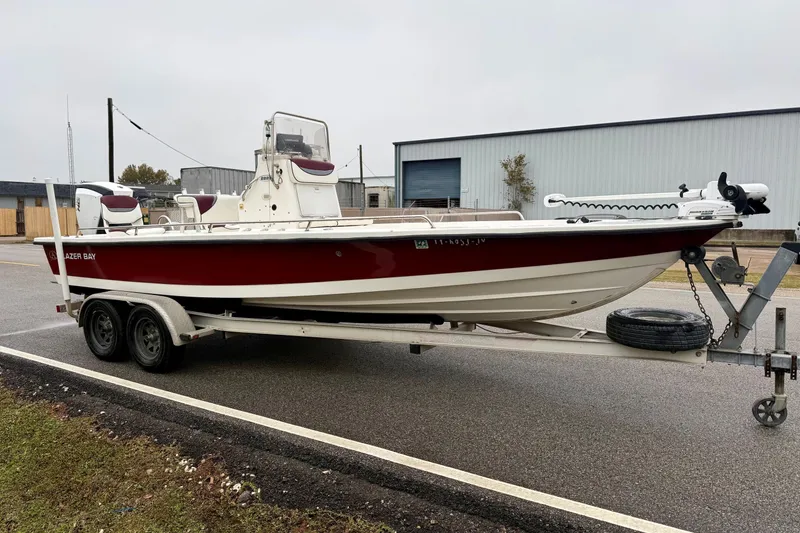 Slide: The Image of 2003 Blazer 2220 Bay boat on trailer, red and white, parked outdoors. - 5