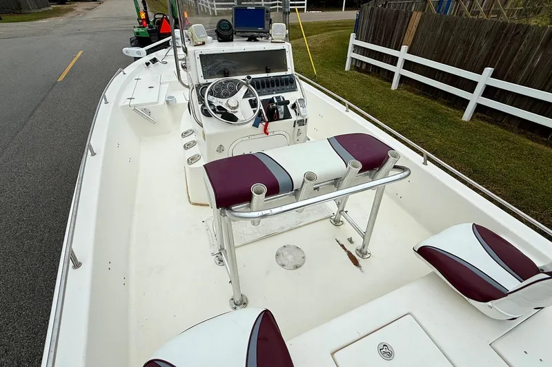 Slide: The Image of 2003 Blazer 2220 Bay boat interior with maroon and white seating, steering console, and equipment. - 8