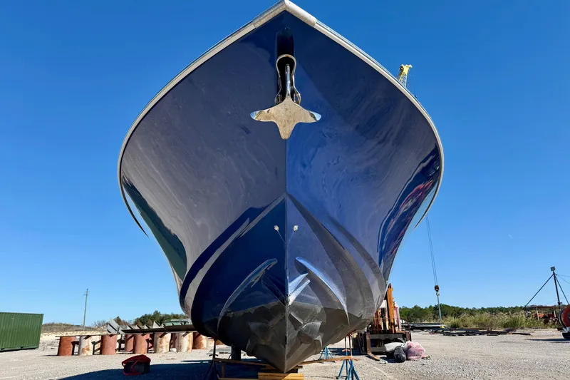 Slide: The Image of 2021 Gulf Crosser 44 boat with sleek blue hull on dry dock under clear sky. - 6