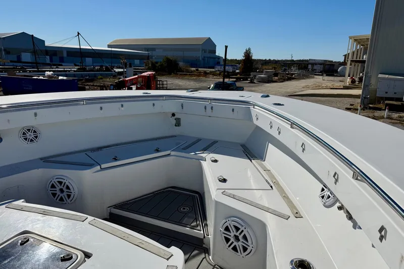 Slide: The Image of 2021 Gulf Crosser 44 boat deck with seating and storage, docked at a shipyard. - 9