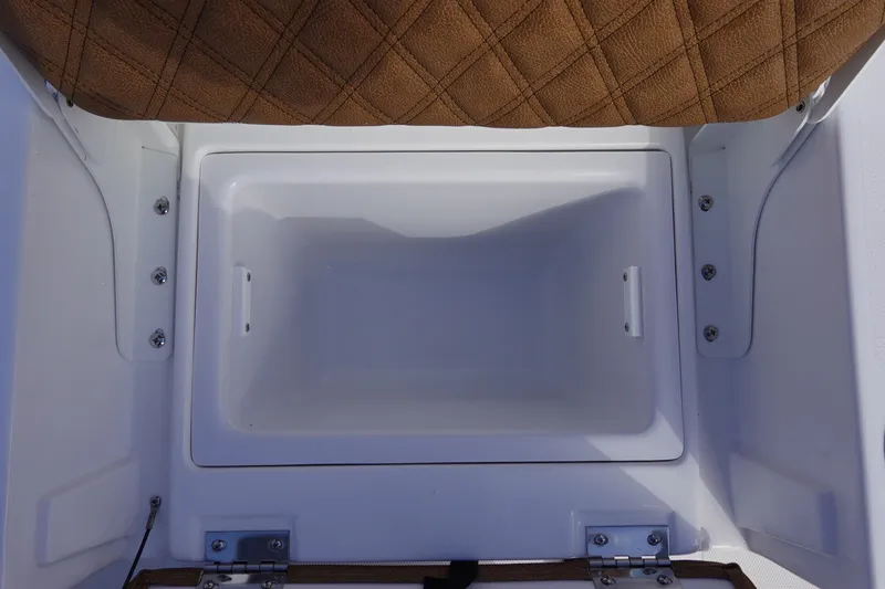 Slide: The Image of 2026 Sea Hunt BX 22 BR boat storage compartment with brown cushioned seat. - 12