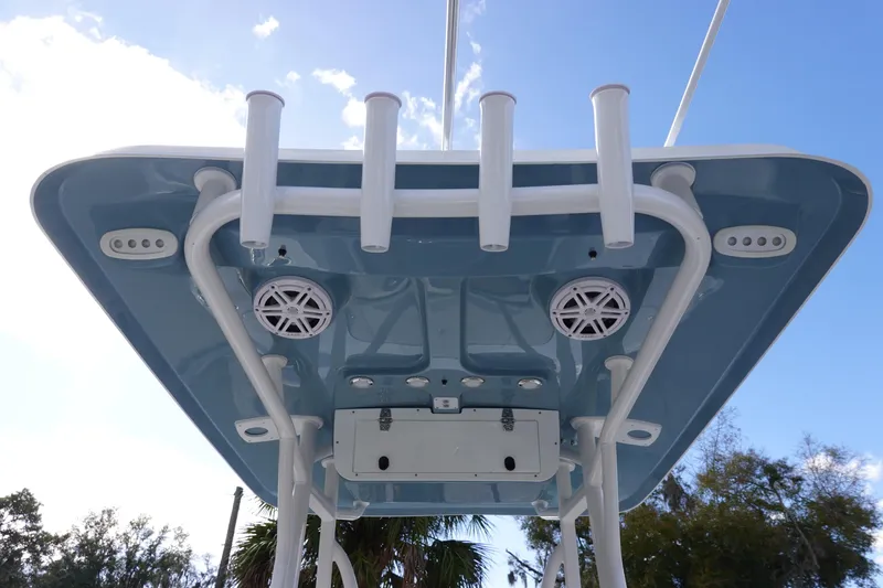 Slide: The Image of 2026 Sea Hunt BX 22 BR boat T-top with rod holders and speakers against blue sky. - 17
