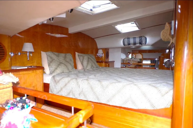 Slide: The Image of Luxurious cabin interior of 2004 Privilege 49 yacht with cozy bedding and wooden finishes. - 2