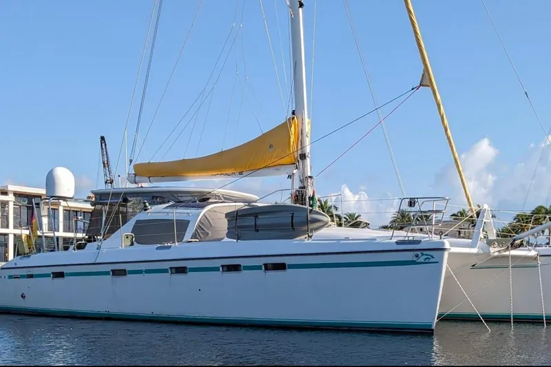 Slide: The Image of 2004 Privilege 49 catamaran with yellow sail docked in marina. - 8
