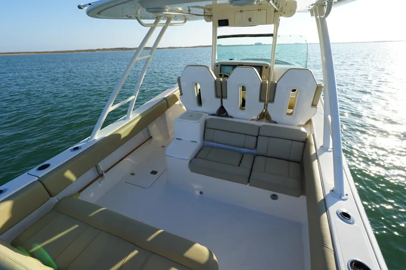 Slide: The Image of 2016 Pursuit ST 310 Sport boat interior with seating, on calm water. - 10