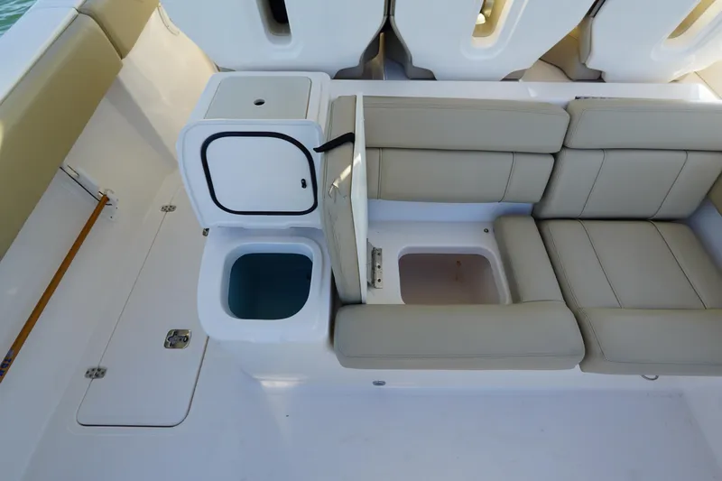 Slide: The Image of 2016 Pursuit ST 310 Sport boat interior with beige seating and storage compartments. - 12