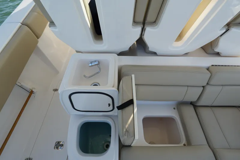 Slide: The Image of 2016 Pursuit ST 310 Sport boat interior with seating and built-in sink. - 13