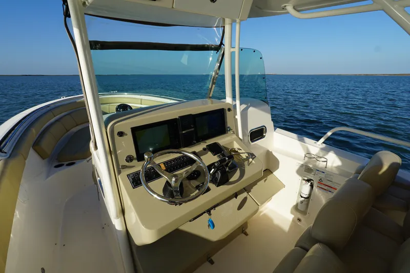 Slide: The Image of 2016 Pursuit ST 310 Sport boat interior with steering console, on open water. - 20
