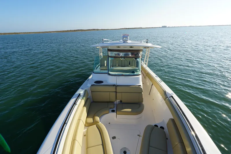 Slide: The Image of 2016 Pursuit ST 310 Sport boat on calm water, featuring spacious seating and sleek design. - 24
