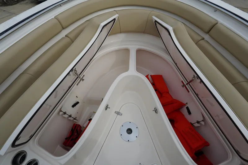 Slide: The Image of 2016 Pursuit ST 310 Sport boat interior with open storage compartments and life jackets. - 29