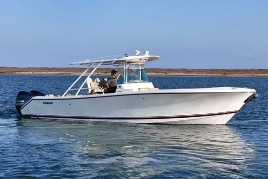 Slide: The Image of 2016 Pursuit ST 310 Sport boat cruising on calm waters under a clear blue sky. - 3