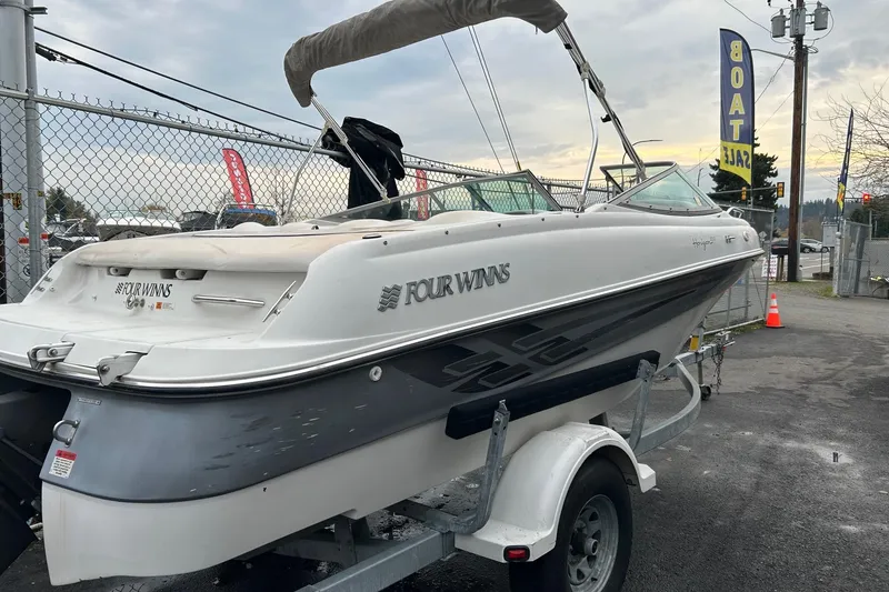Slide: The Image of 2000 Four Winns 200 Horizon boat on trailer at dealership, overcast sky. - 16