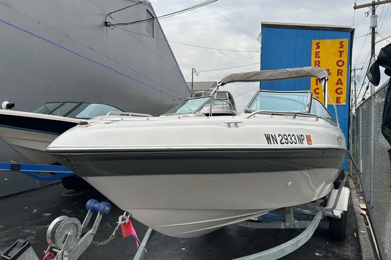 Slide: The Image of 2000 Four Winns 200 Horizon boat on trailer, parked near storage facility. - 17