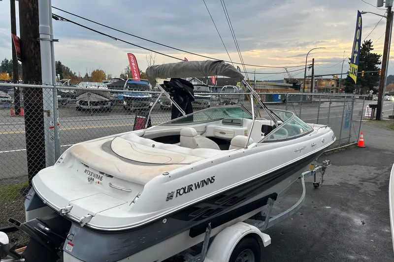 Slide: The Image of 2000 Four Winns 200 Horizon boat on trailer in parking lot, overcast sky. - 2