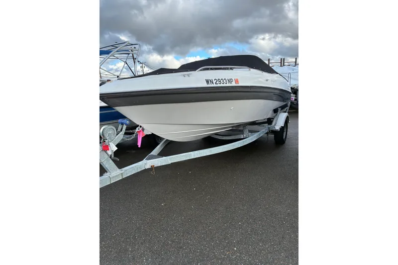 Slide: The Image of 2000 Four Winns 200 Horizon boat on trailer under cloudy sky. - 5