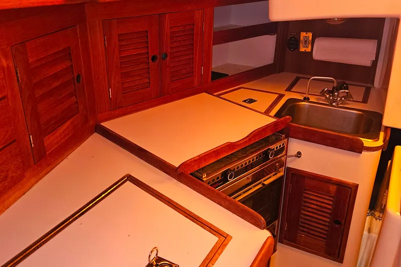 Slide: The Image of 1994 Tartan 3100 yacht kitchen with wooden cabinets and stainless steel sink. - 12