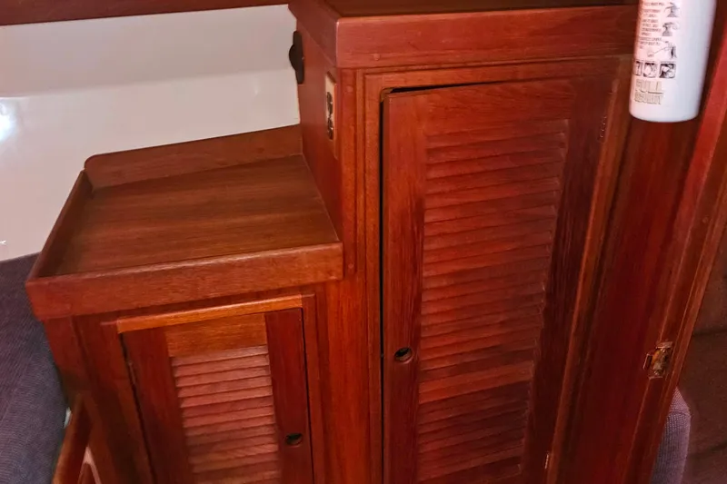 Slide: The Image of Wooden interior of a 1994 Tartan 3100 sailboat, featuring louvered cabinets. - 16