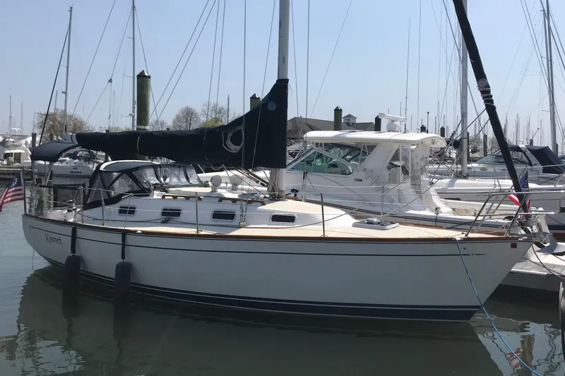 Slide: The Image of Sailboat docked in marina, Tartan 3100 model, 1994, with American flag. - 2