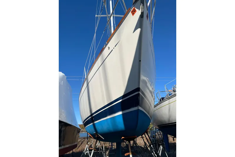 Slide: The Image of 1994 Tartan 3100 sailboat on stands, viewed from the bow under a clear blue sky. - 4
