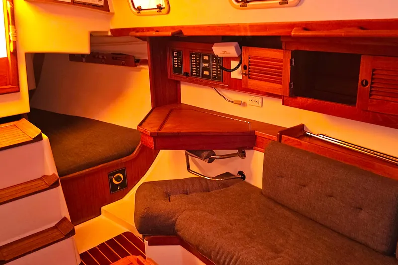 Slide: The Image of Cozy interior of a 1994 Tartan 3100 sailboat with wooden cabinetry and seating. - 8