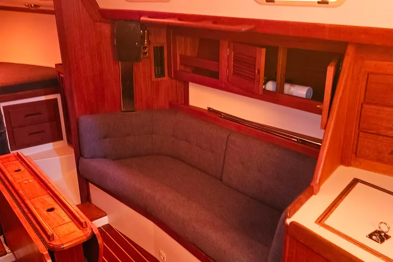 Slide: The Image of Cozy interior of a 1994 Tartan 3100 sailboat with wooden cabinetry and cushioned seating. - 9