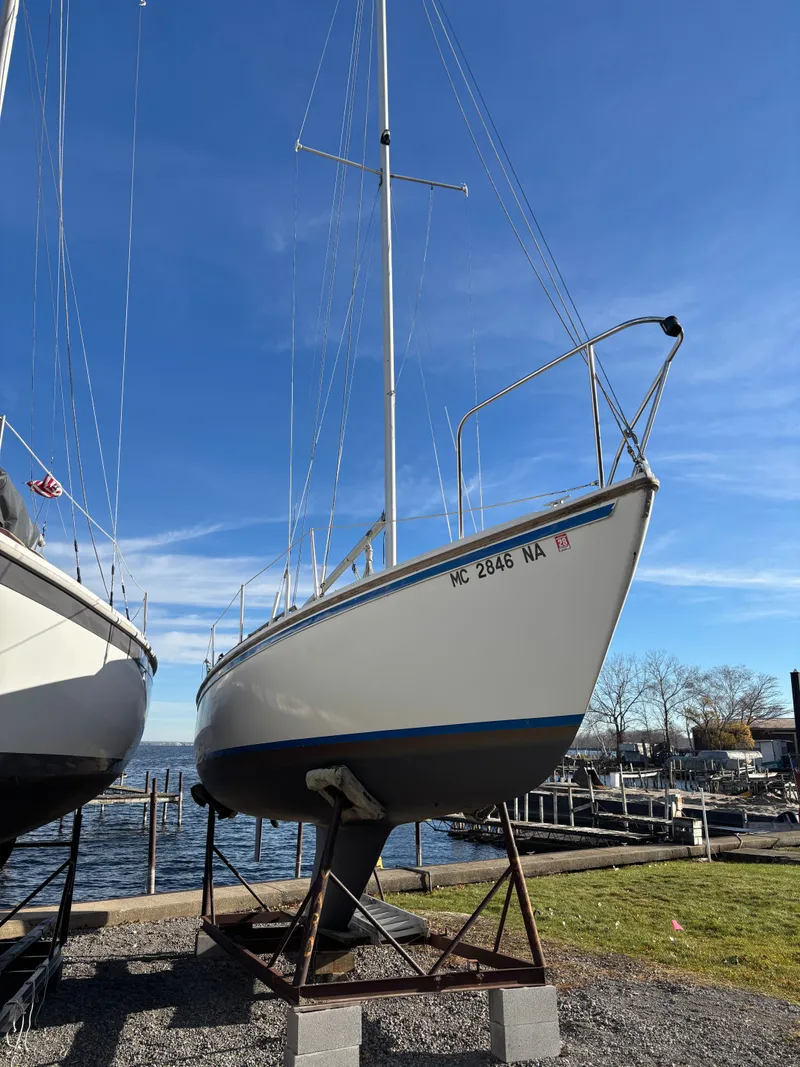 Slide: The Image of 1986 Catalina 25 sailboat on a stand by the water. - 2