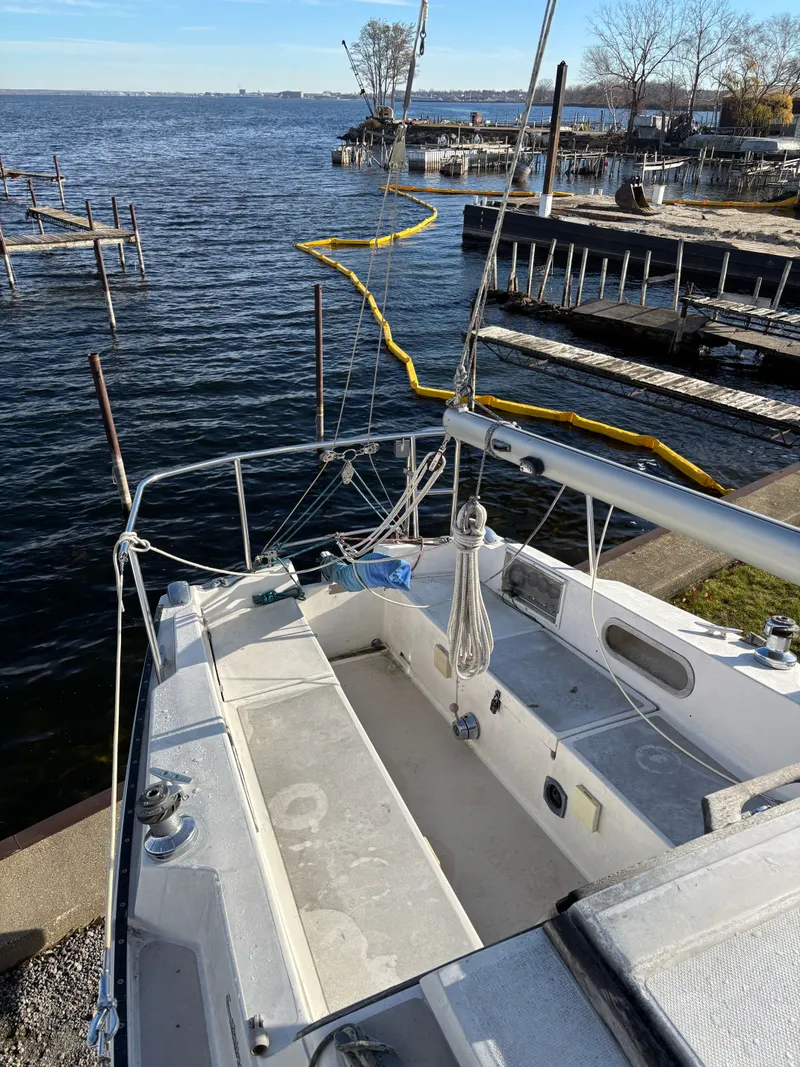Slide: The Image of 1986 Catalina 25 sailboat docked by calm waters. - 21