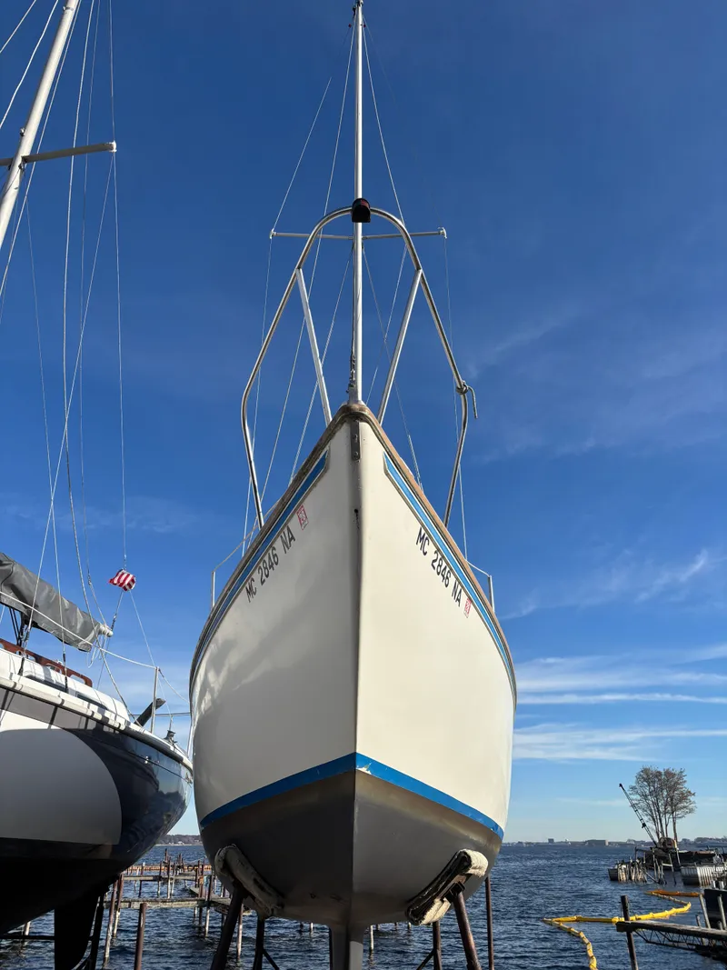 Slide: The Image of 1986 Catalina 25 sailboat docked against blue sky. - 3