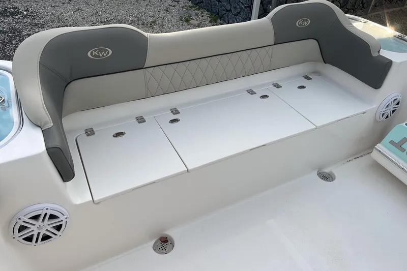 Slide: The Image of 2026 Key West 263 FS boat seating area with storage compartments and speakers. - 15