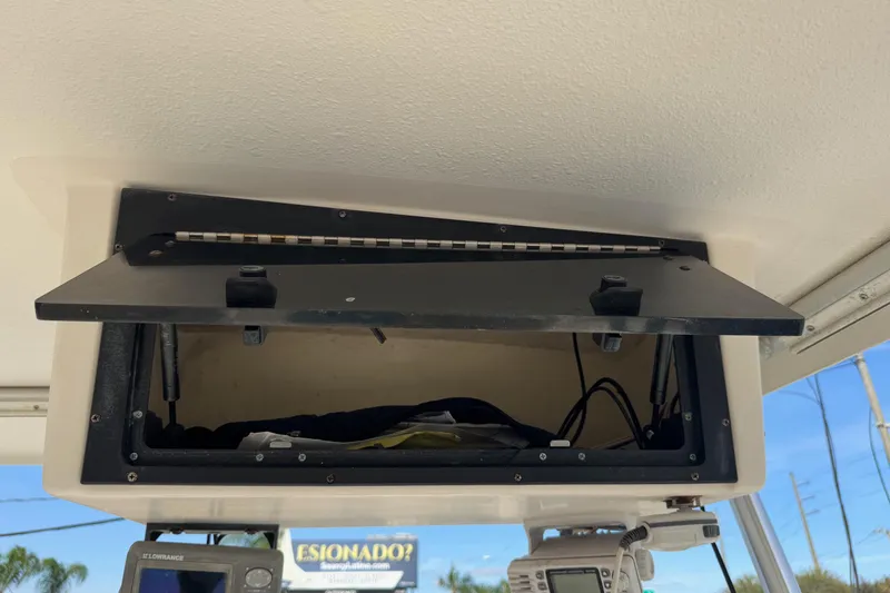 Slide: The Image of Open storage compartment on 2006 Mako 253 Walk Around boat, showing interior and equipment. - 12